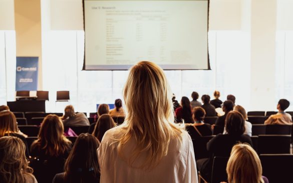 Kobieta przemawiająca przed publicznością podczas prezentacji biznesowej